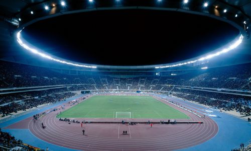 Estadio de la Cartuja en Sevilla Diseño Interior del Graderio con la cubierta sobre la campo de futbol y la pista de atletismo de noche Cruz y Ortiz