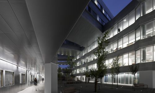 Facultad de Ciencias de la Educación en Sevilla Diseño exterior nocturno de paso y recorrido por patio de Cruz y Ortiz Arquitectos
