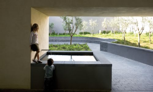 Lofts en Fabrica de Sabadell en Barcelona Diseño de jardin y fuente exterior en patio de adoquines de Cruz y Ortiz Arquitectos