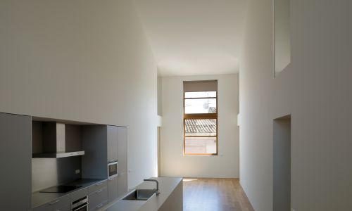 Lofts en Fabrica de Sabadell en Barcelona Diseño interior de cocina y espacio a doble altura de vivienda de Cruz y Ortiz Arquitectos