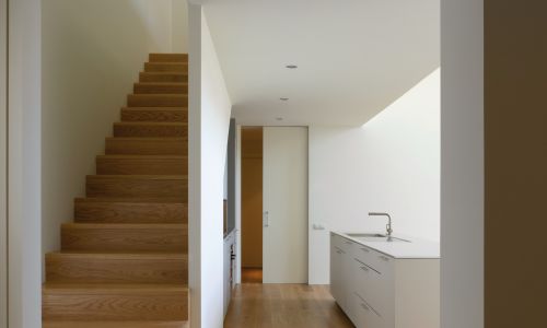 Lofts en Fabrica de Sabadell en Barcelona Diseño interior de escalera de madera y cocina integrada en salón de Cruz y Ortiz Arquitectos