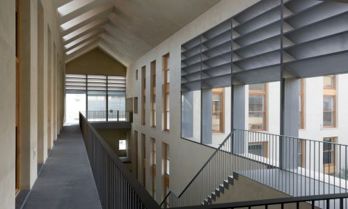 Lofts en Fabrica de Sabadell en Barcelona Diseño interior de zona común de viviendas accesos a través de atrio con lucernario en cubierta de Cruz y Ortiz Arquitectos