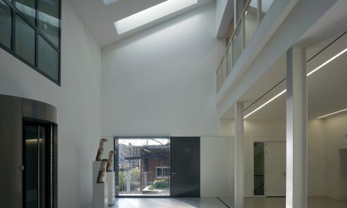 Instituto holandes del patrimonio de cultura en atelier Diseño interior de entrada al vestíbulo de doble altura iluminada por lucernario Cruz y Ortiz Arquitectos